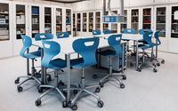 Moderner SFZ-Raum mit einem großen Tisch und mehreren blauen Stühlen, umgeben von Schränken mit Laborgeräten.