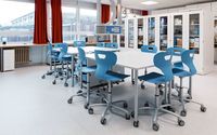 Moderner SFZ-Raum mit einem großen Tisch und mehreren blauen Stühlen, umgeben von Schränken mit Laborgeräten.