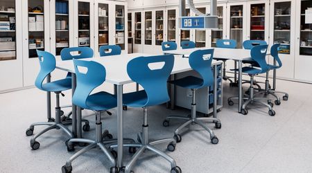 Moderner SFZ-Raum mit einem großen Tisch und mehreren blauen Stühlen, umgeben von Schränken mit Laborgeräten.