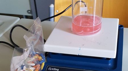 Ein Becherglas auf einem Magnetrührer für ein Experiment zum Färben von Wollfäden mit Lakritzstäben