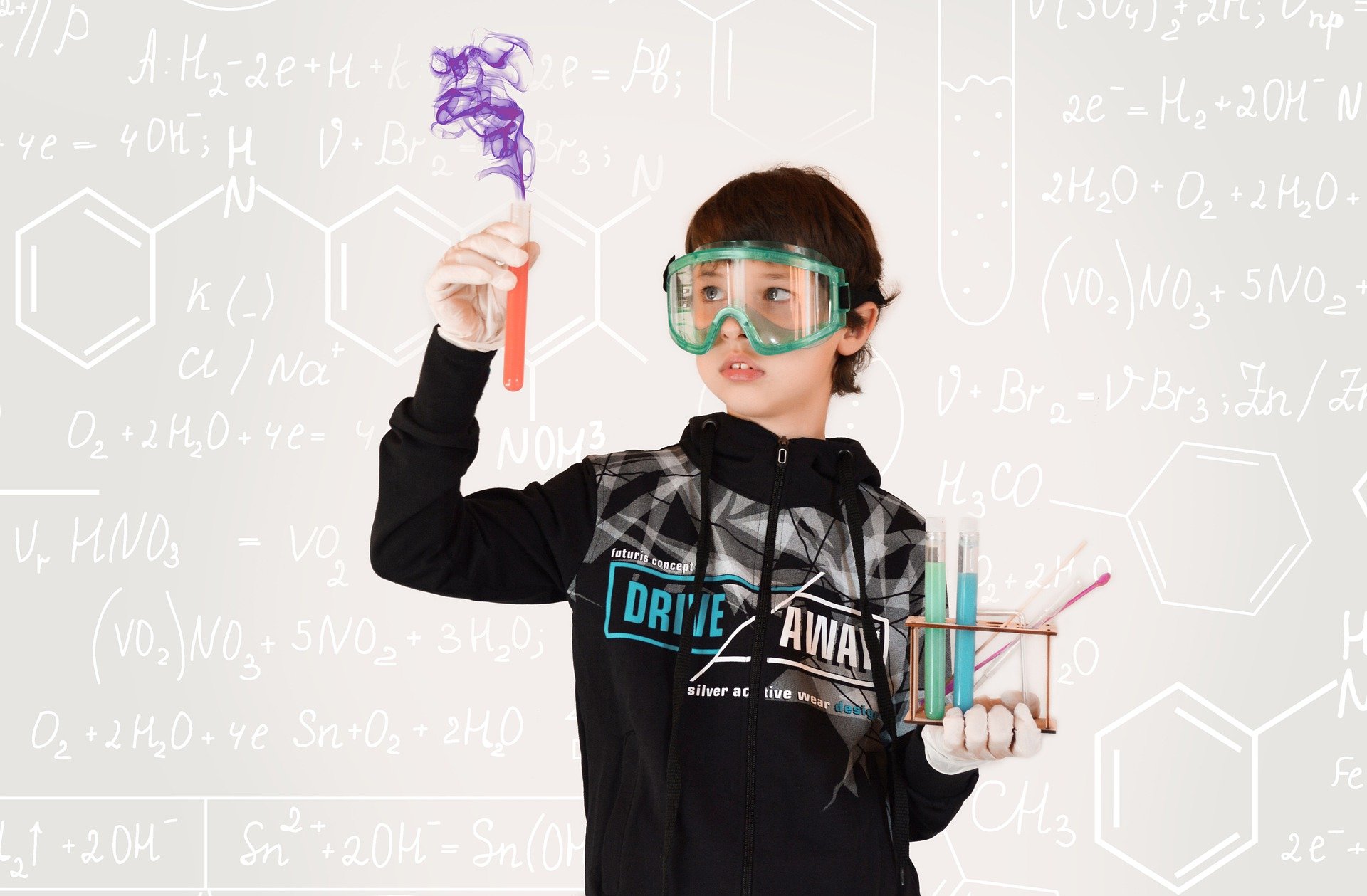 Junger Schüler trägt Schutzbrille und hält ein Reagenzglas mit violettem Rauch sowie ein Reagenzglasgestell, vor einem Hintergrund mit chemischen Formeln und Molekülstrukturen.